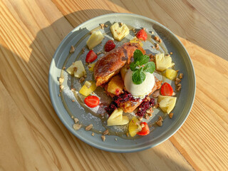 French Toast with ice cream scoop and tropical fruit at timber wooden table, perfect high resolution image for display products