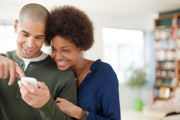 Couple using cell phone in living room