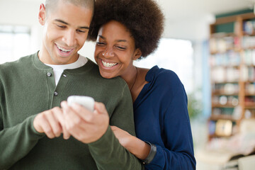 Couple using cell phone in living room