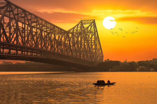Howrah bridge with fishing boat on river Ganges at sunrise at Kolkata India