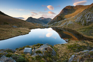 Adelaide Tarn and hut with hiker,  Kahurangi National Park