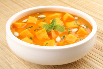 Healthy vegetarian meal- homemade delicious organic  pumpkin fresh cream soup served in ceramic bowl.