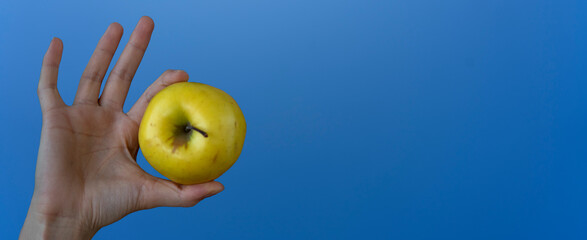 female hand banner shows an apple on a light blue background