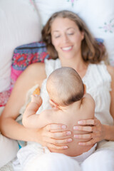 Mother holding baby boy on bed