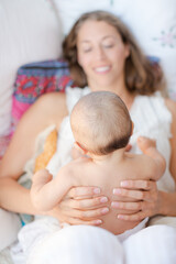 Mother holding baby boy on bed