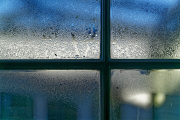 Condensation on the inside of a window in a cold damp house.