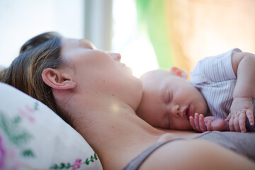 Obraz na płótnie Canvas Mother and baby girl sleeping on bed