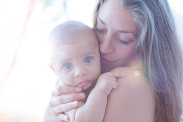 Obraz na płótnie Canvas Bare chested mother holding baby boy