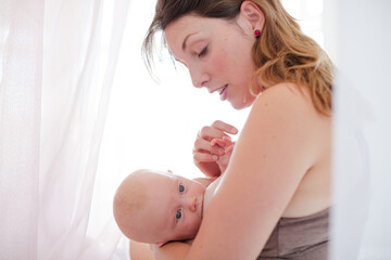 Mother breast-feeding baby girl