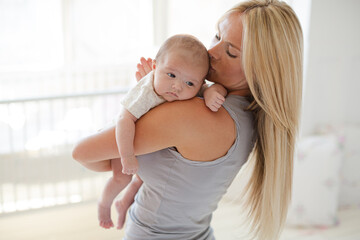 Mother holding baby girl in nursery