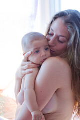 Bare chested mother holding baby boy