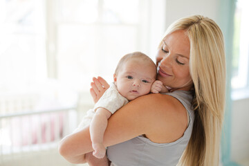 Mother holding baby girl in nursery
