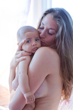 Bare chested mother holding baby boy