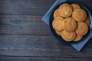 Natural homemade oatmeal cookies on a plate, dark wooden background, copy space.