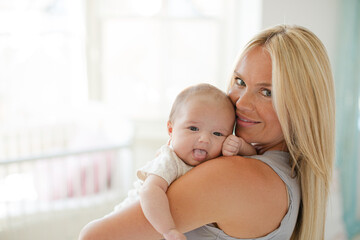 Mother holding baby girl in nursery