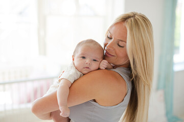 Mother holding baby girl in nursery
