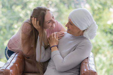 Woman and female cancer patient cuddle together for the symbol of support and encouragement.