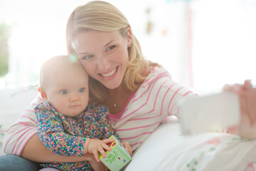 Mother taking self-portrait with baby girl