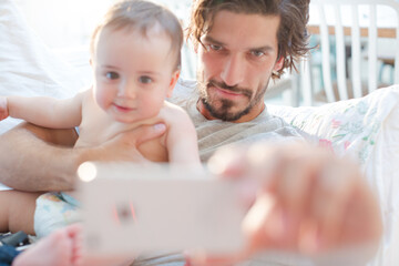Father taking self-portrait with baby boy