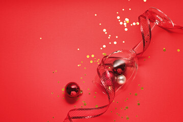 christmas decor with sparkles and balls on red festive background with copy space, flat lay. concept new year holidays background 2022
