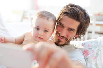 Father taking self-portrait with baby boy