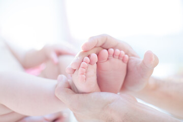 Father cradling baby boy's feet
