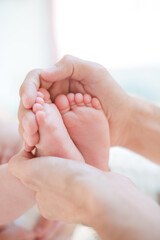 Father cradling baby boy's feet