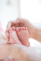 Father cradling baby boy's feet