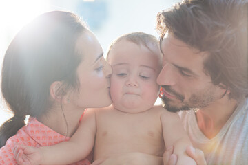 Parents kissing baby boy's cheeks