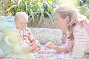 Mother and baby girl playing with xylophone outdoors