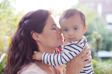 Mother holding baby girl outdoors
