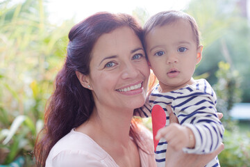 Mother holding baby girl outdoors