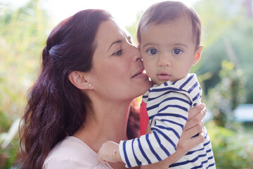 Mother holding baby girl outdoors