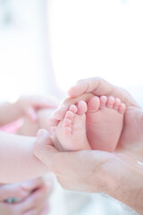 Obraz na płótnie Canvas Father cradling baby boy's feet