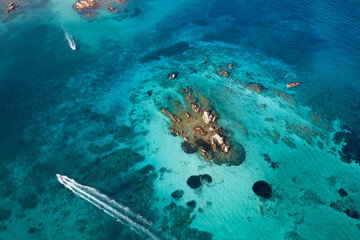 Obraz premium View from above, stunning aerial view of some boats sailing on a crystal clear, turquoise water. Giardinelli island, La Maddalena Archipelago, Sardinia, Italy.