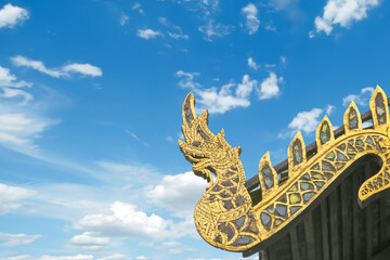 Fototapeta na wymiar Beautiful Old golden serpent or naga on art roof of buddhist temple, Gable of the Thai Northern art style, Buddhist temple with blue sky in Temple of Thailand
