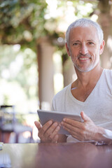 Man using digital tablet at table