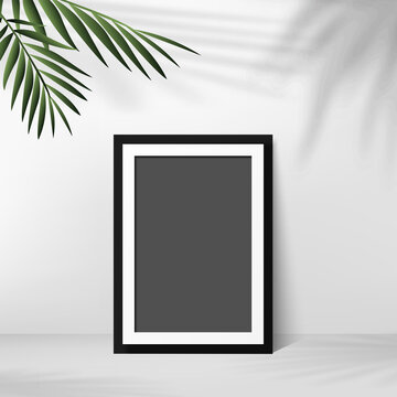 Black photo frame with palm leaves in white background. Vector
