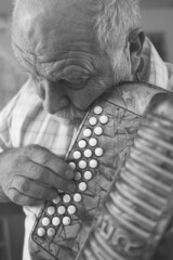 senior caucasian from the alps playing harmonica acordeon folk songs