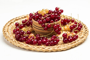 Berries of white and red currants on wicker plate.