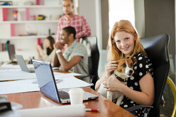 Dog sitting on woman lap in office
