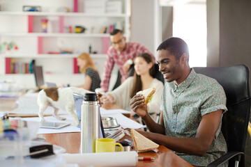 Man eating and working at conference tablet