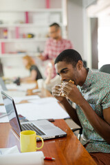Man eating and working at conference tablet