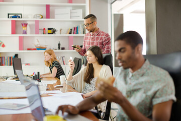 Man eating and working at conference tablet