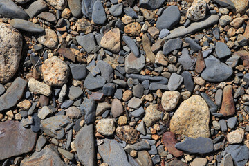 River pebbles on the river bank at Magadan region, top view. Gravel texture background