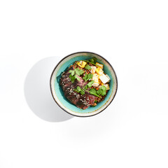 Traditional oriental food - fried rice with egg and beef. Stir-fry rice in asian style on white background. Meat and rice with omelette in bowl. Isolated on white background.