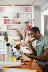 Man eating and working at conference tablet