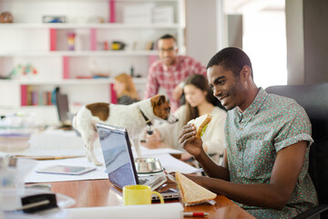 Man eating and working at conference tablet