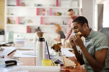 Man eating and working at conference tablet