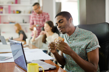 Man eating and working at conference tablet